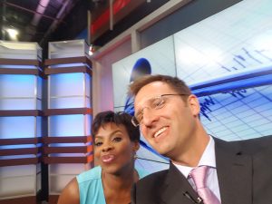 Dr. Steven Chudik, orthopaedic surgeon and sports medicine specialist with the Steven Chudik Shoulder, Knee and Sports Medicine Injury Clinic in Westmont, Ill., demonstrates the cause of the newest repetitive use injury, the selfie elbow, to Fox 32 Chicago morning news anchor, Darlene Hill.